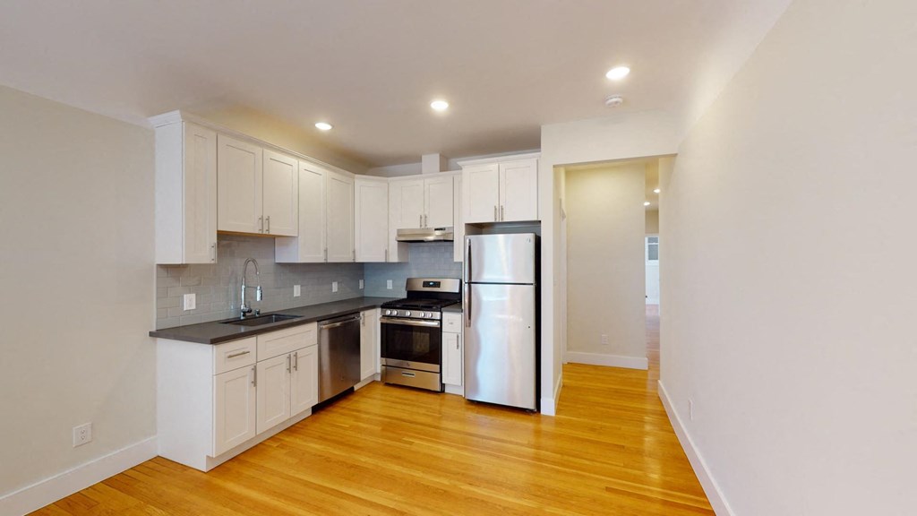 a kitchen with white cabinets and stainless steel appliances