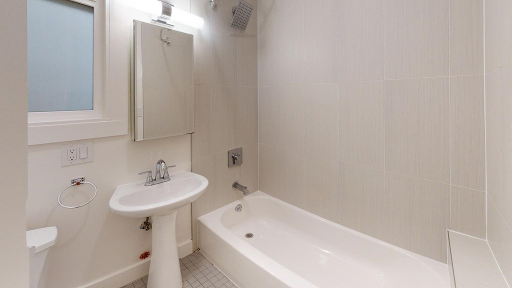 a white bathroom with a tub and a sink