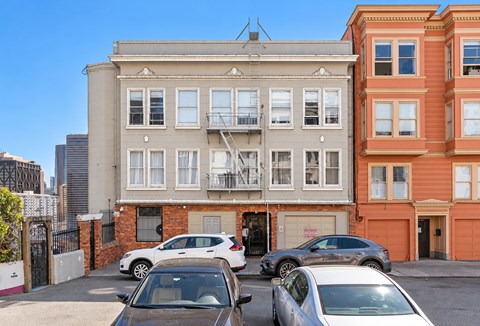 A row of parked cars in front of a building.