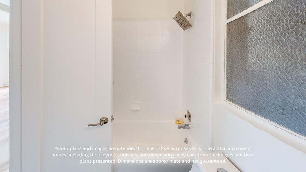 a white bathroom with a shower and a window