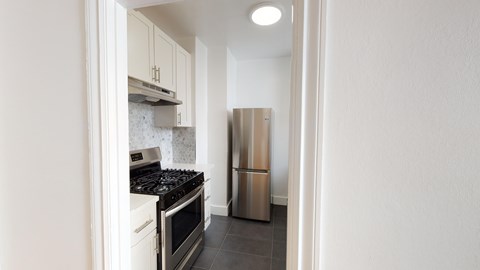 A kitchen with a stove and a refrigerator.