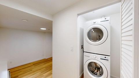 A white washing machine is in a small room.