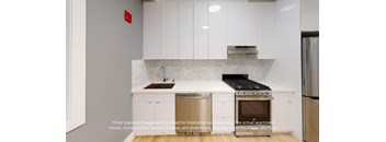 a small kitchen with white cabinets and a stainless steel stove and refrigerator