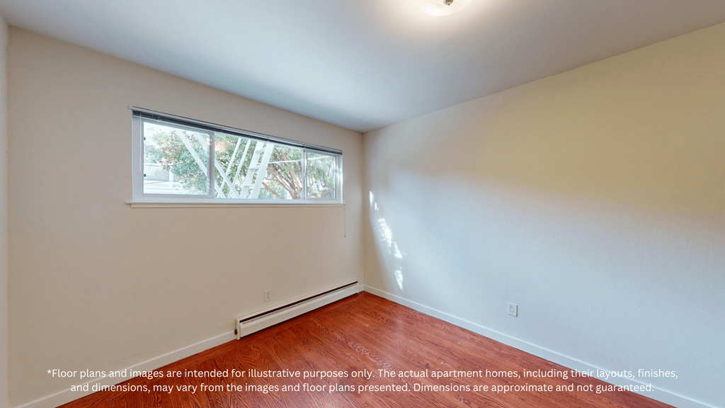 A room with a window and a wooden floor.