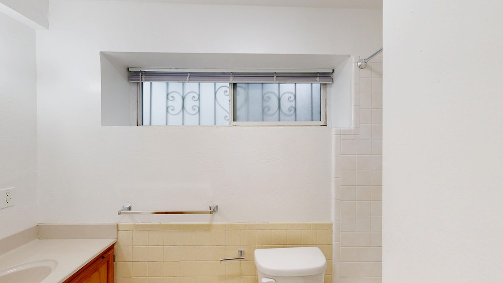 A white toilet sits next to a sink in a bathroom.