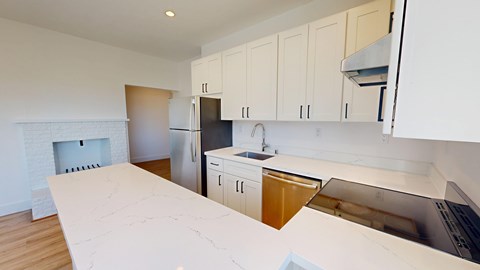 A kitchen with white cabinets and a white counter top.