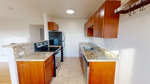 A kitchen with wooden cabinets and granite countertops.