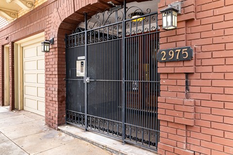 A black wrought iron gate with a mailbox on it.