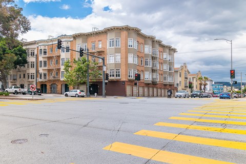 A street view of a crosswalk with a building in the background.