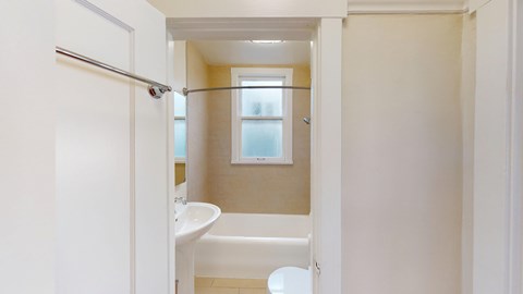 A white bathroom with a tub and toilet.
