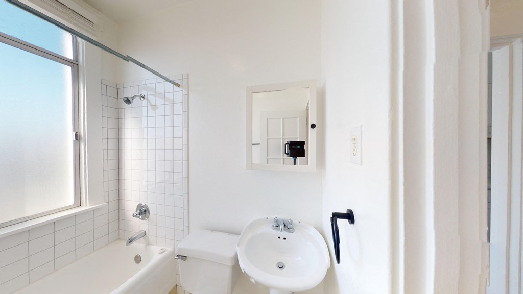 a bathroom with a sink and a toilet and a window