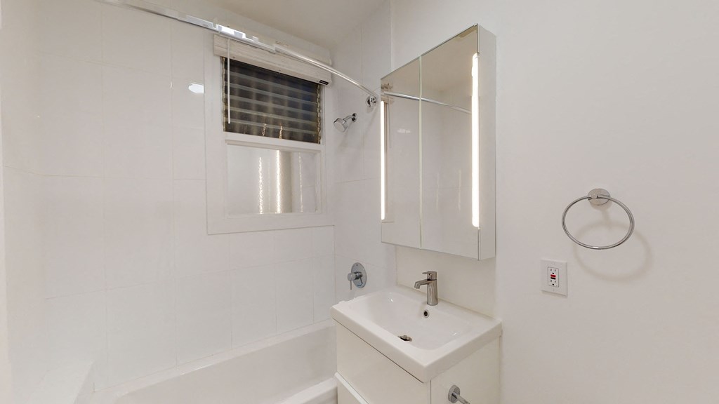 a white bathroom with a sink and a mirror