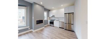 a renovated kitchen with white cabinets and stainless steel appliances