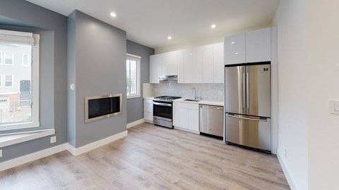 a renovated kitchen with white cabinets and stainless steel appliances