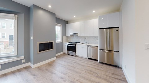 a renovated kitchen with white cabinets and stainless steel appliances