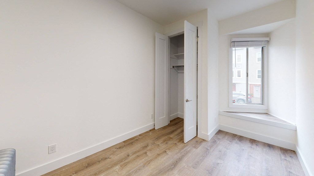 a living room with a window and a door to a closet