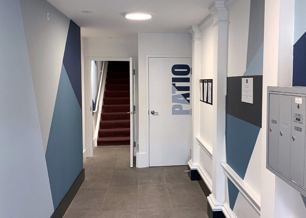 a hallway with blue and white walls and a staircase with a white door