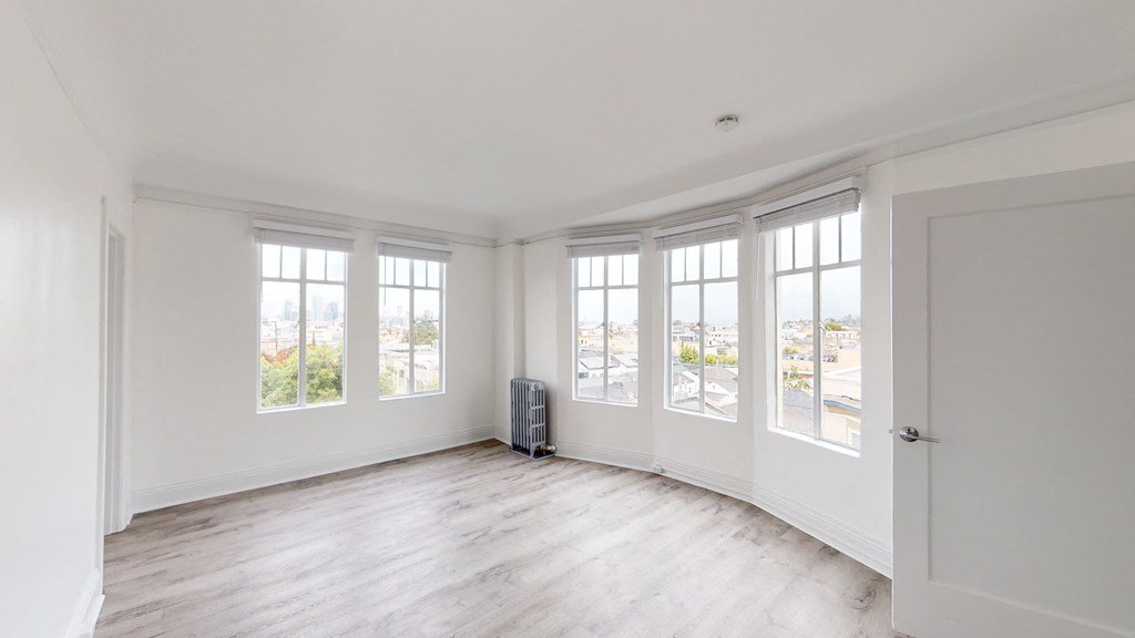 an empty living room with white walls and windows