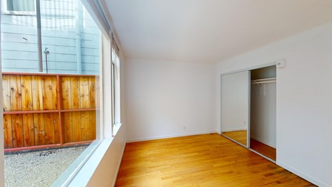 A room with wooden floors and a sliding glass door.