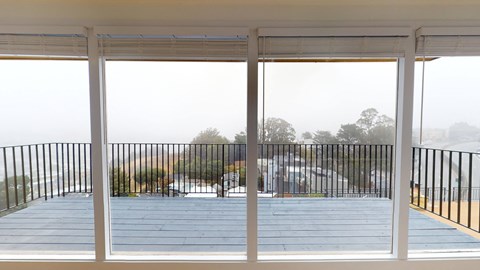 a view of the deck from inside a house with large windows