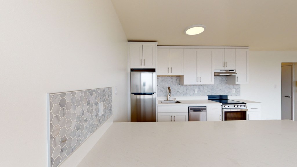 a kitchen with white cabinets and a white counter top
