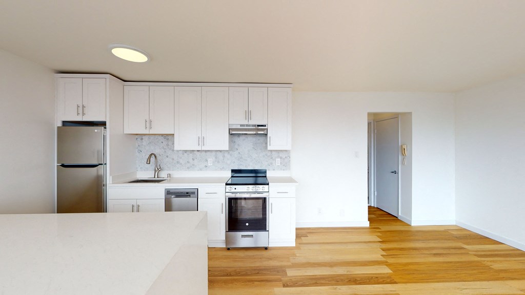 a renovated kitchen with white cabinets and stainless steel appliances