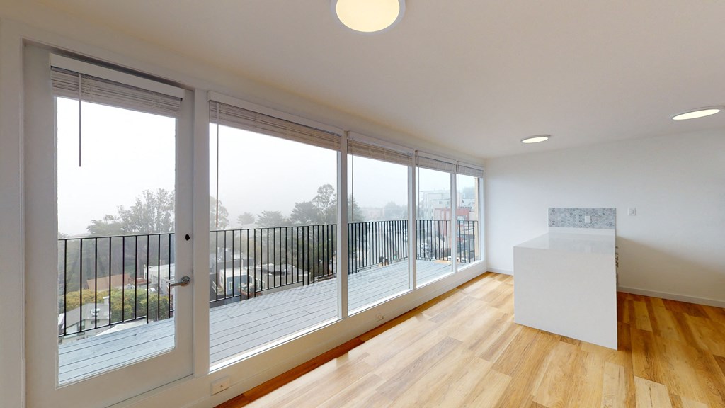 a living room with large windows and a balcony