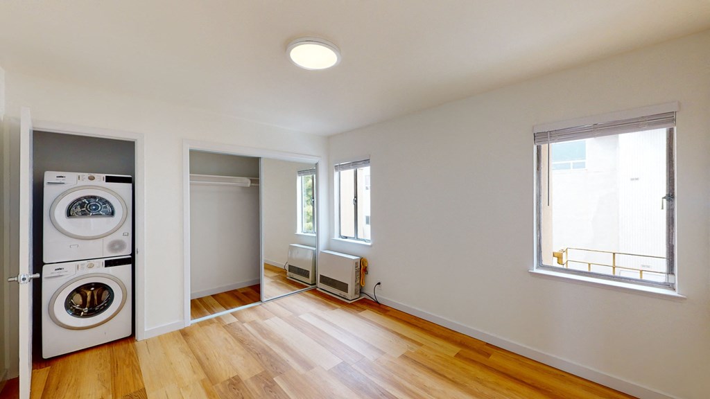 a living room with a washer and a dryer in it and a window