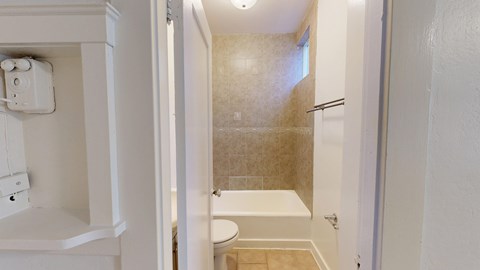 A white bathroom with a toilet, sink, and shower.