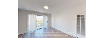 an empty living room with white walls and a sliding glass door