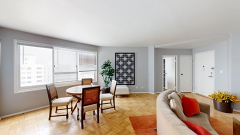 A living room with a couch, chairs, and a table.