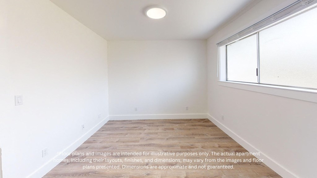 an empty room with white walls and a large window