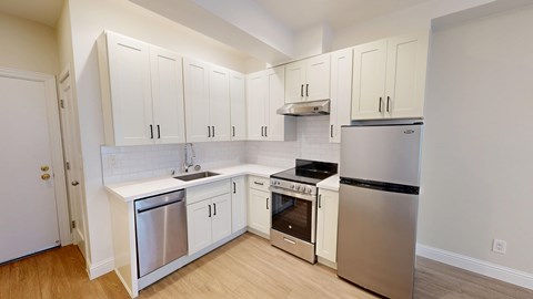 A kitchen with white cabinets and stainless steel appliances.