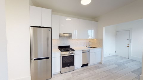 a kitchen with white cabinets and a stainless steel refrigerator