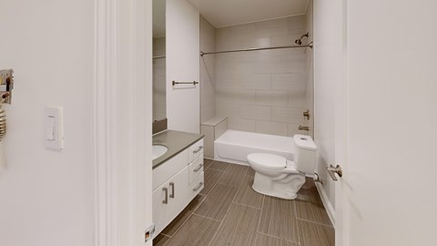 A white bathroom with a toilet, sink, and shower.