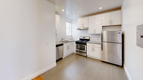 A kitchen with stainless steel appliances and white cabinets.