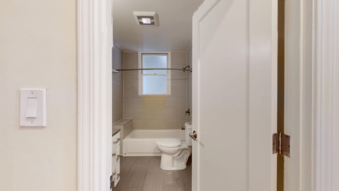A white bathroom with a toilet, sink, and bathtub.