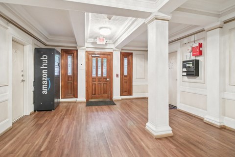 A hallway with a black Amazon box on the floor.