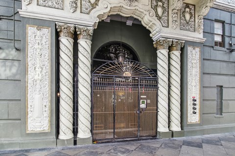 A large ornate gate is closed and locked.