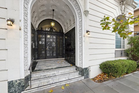 A white building with a black door and a hanging light.