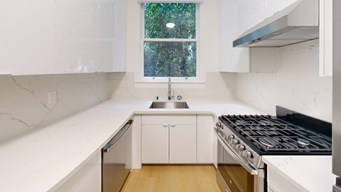 A kitchen with white cabinets and a black stove top.