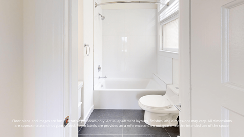 A white toilet is in a small bathroom with a glass shower door.