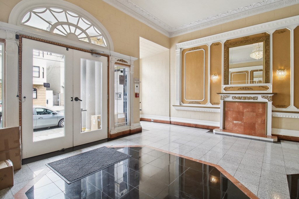 Grand entrance to a building, featuring a large archway, a fireplace, and a doormat