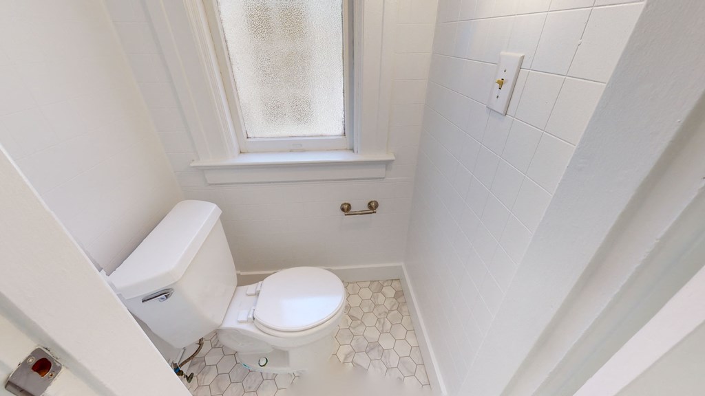 a small bathroom with a toilet and a window
