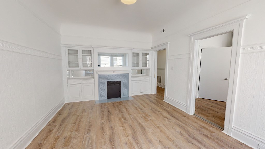 a living room with white cabinets and a fireplace