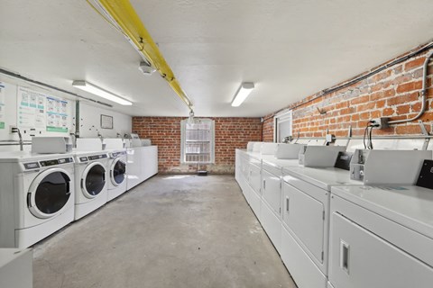 Well-lit laundry room with washing machines and dryers