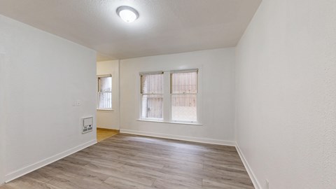A room with a window and a wooden floor.