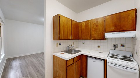 A kitchen with white appliances and wooden cabinets.