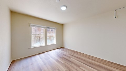 A room with a window and wooden flooring.