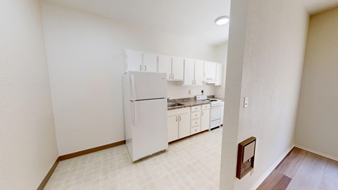 A kitchen with white appliances and cabinets.